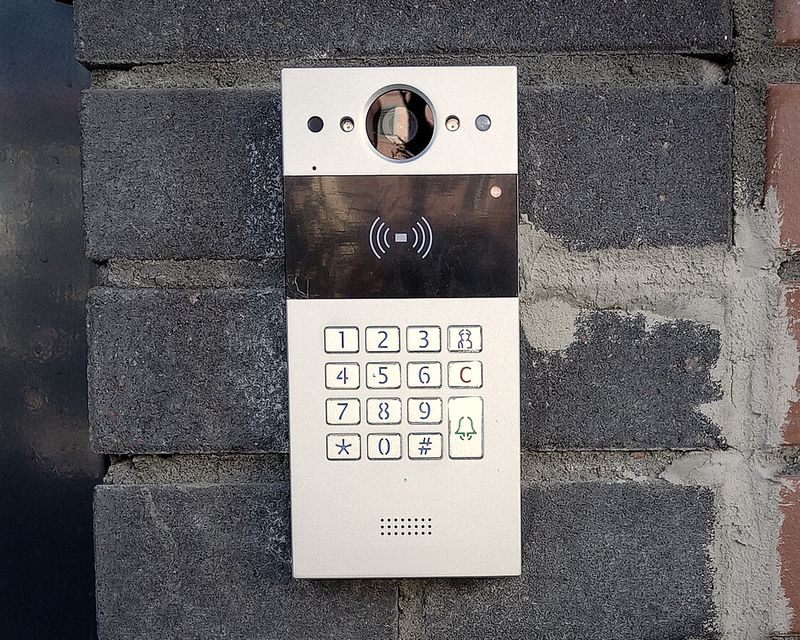 Stainless video intercom with camera, card reader, and keypad at a building entrance